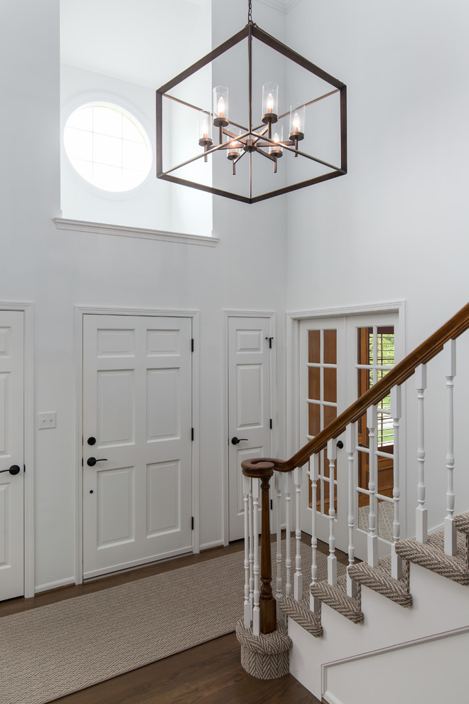Источник вдохновения для домашнего уюта: фойе в стиле неоклассика (современная классика) с белыми стенами, темным паркетным полом, одностворчатой входной дверью и белой входной дверью