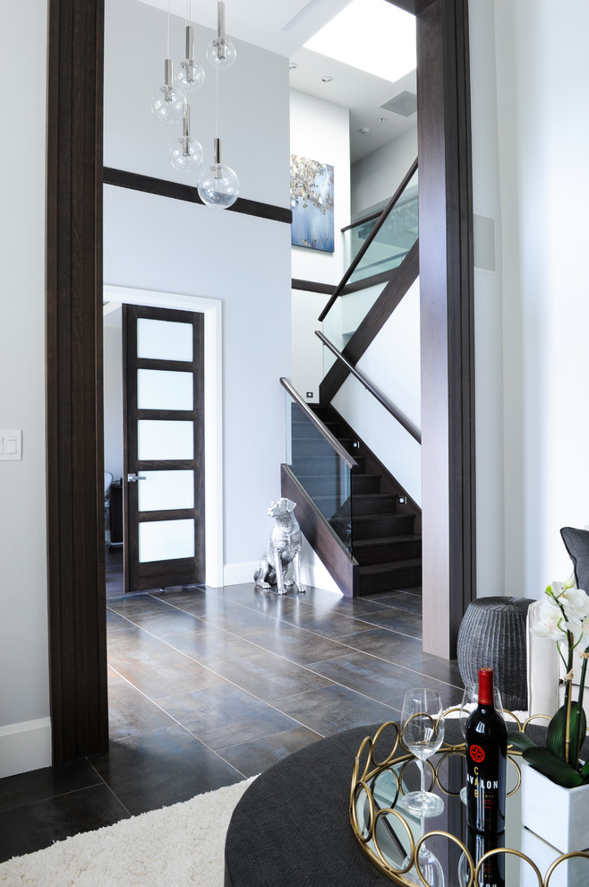 Transitional brown floor foyer photo in Vancouver with white walls