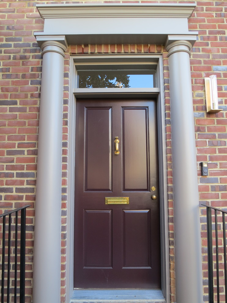 Immagine di una porta d'ingresso tradizionale di medie dimensioni con una porta singola e una porta rossa