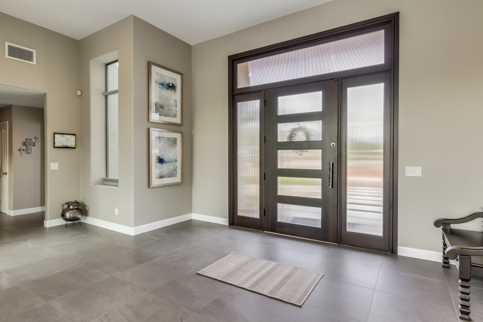 Inspiration for a large contemporary front door in Phoenix with grey walls, porcelain flooring, a dark wood front door and grey floors.