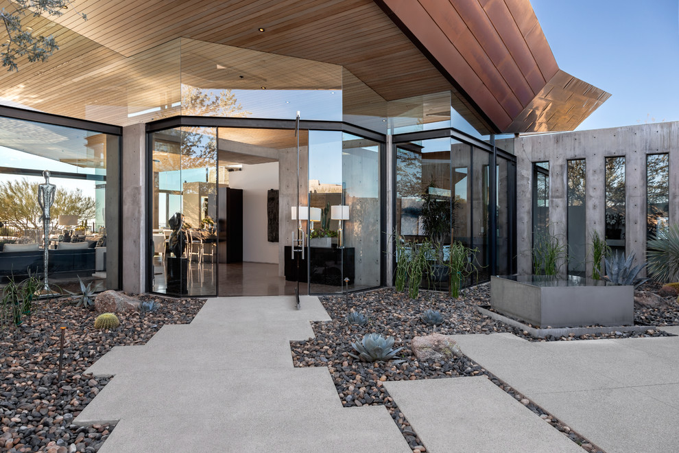 Photo of a contemporary front door in Phoenix with grey walls, a pivot front door and a glass front door.