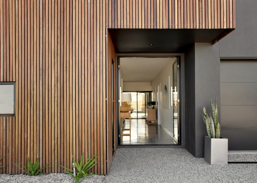 Esempio di una porta d'ingresso minimalista di medie dimensioni con pareti nere, pavimento in cemento, una porta a due ante, una porta nera e pavimento grigio