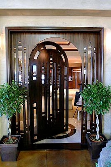 На фото: входная дверь в стиле неоклассика (современная классика) с одностворчатой входной дверью и входной дверью из темного дерева с