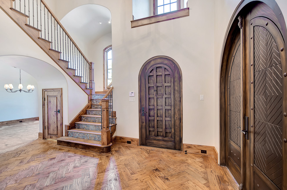 Ejemplo de puerta principal rústica con paredes beige, suelo de madera en tonos medios, puerta simple y puerta de madera oscura