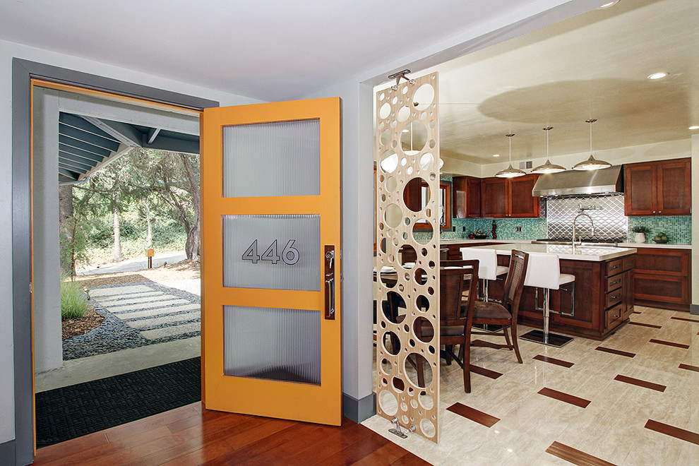 Exempel på en 60 tals ingång och ytterdörr, med vita väggar, betonggolv, en enkeldörr och en orange dörr