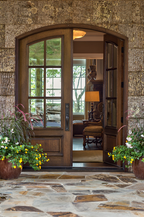Inspiration pour une grande porte d'entrée traditionnelle avec une porte double et une porte en bois foncé.