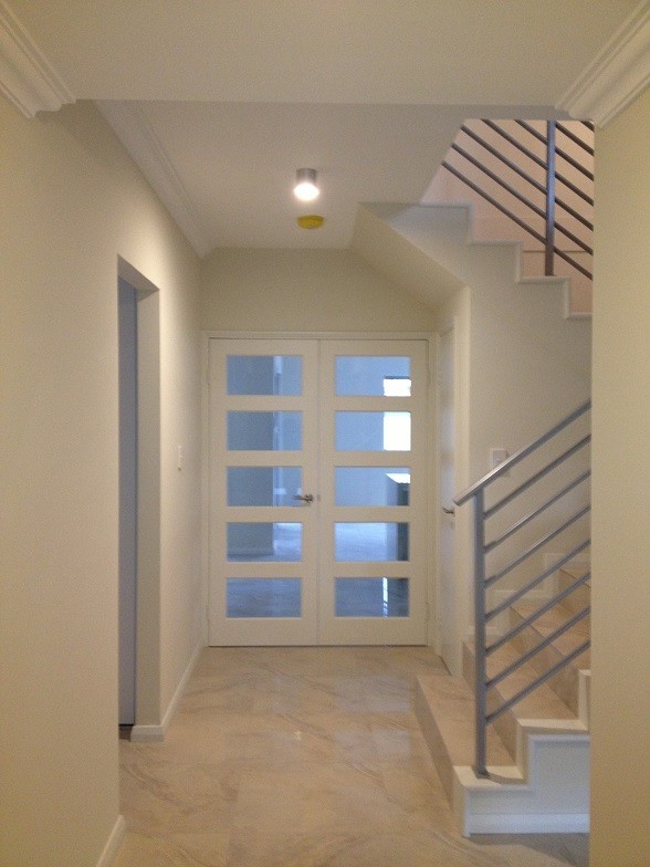 Immagine di un grande ingresso o corridoio minimal con pareti beige e pavimento con piastrelle in ceramica