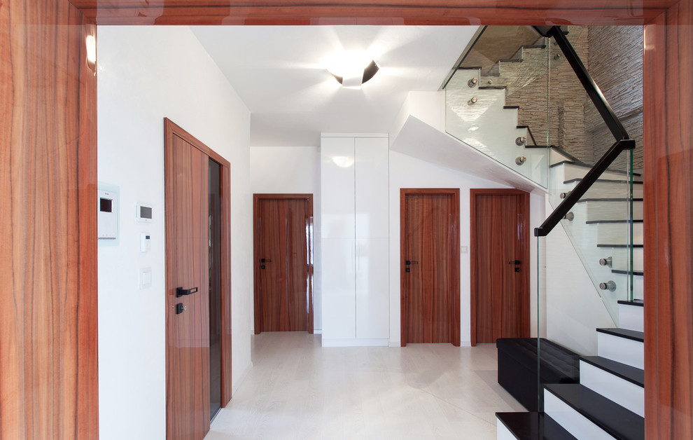 Diseño de puerta principal actual de tamaño medio con paredes blancas, suelo de contrachapado, puerta simple y puerta blanca