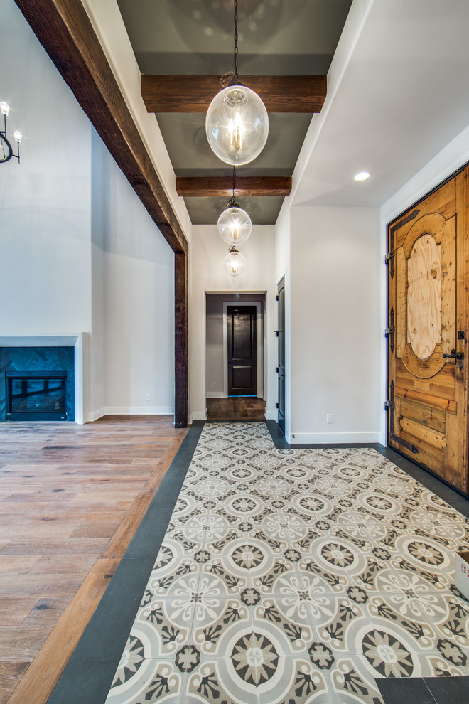 Inspiration pour un hall d'entrée traditionnel de taille moyenne avec un mur gris, une porte en bois clair et un sol multicolore.