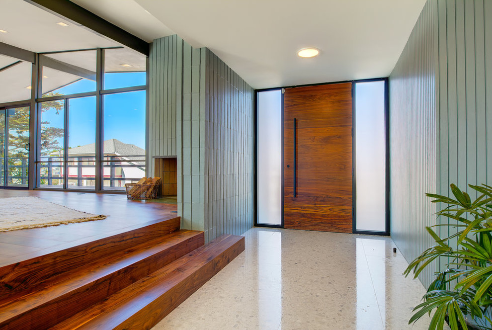 Ispirazione per un corridoio moderno con pareti verdi, una porta singola, una porta in legno bruno e pavimento grigio