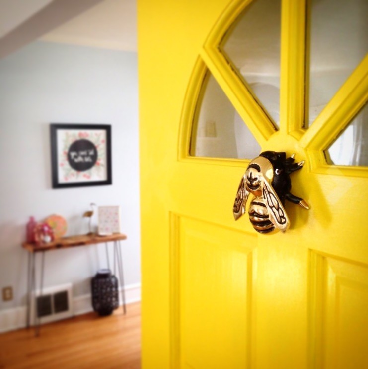 Ejemplo de entrada minimalista con puerta simple y puerta amarilla