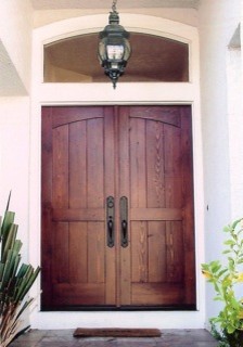 На фото: большая входная дверь в современном стиле с двустворчатой входной дверью и входной дверью из дерева среднего тона