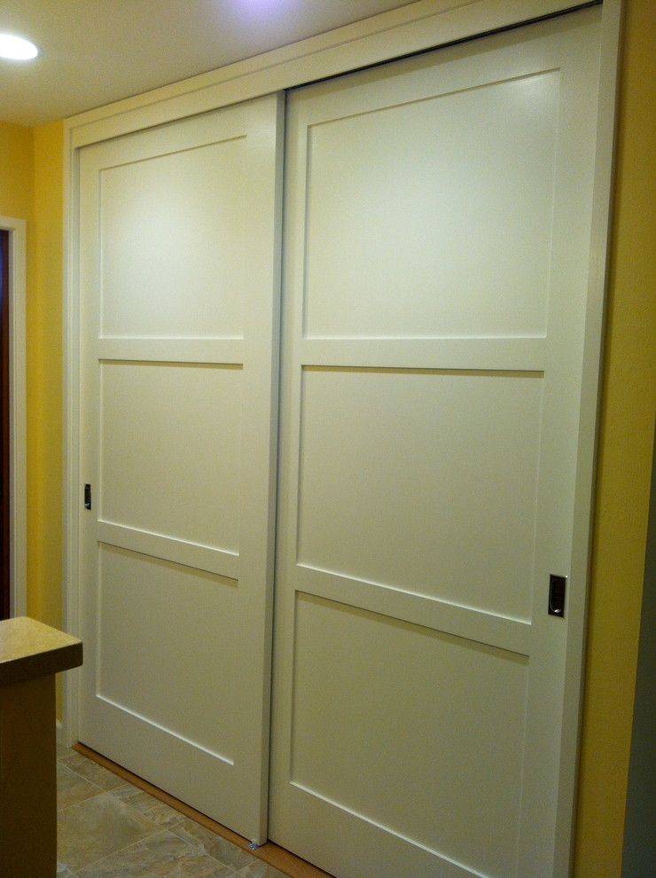 Idéer för mellanstora funkis hallar, med gula väggar, travertin golv och en vit dörr