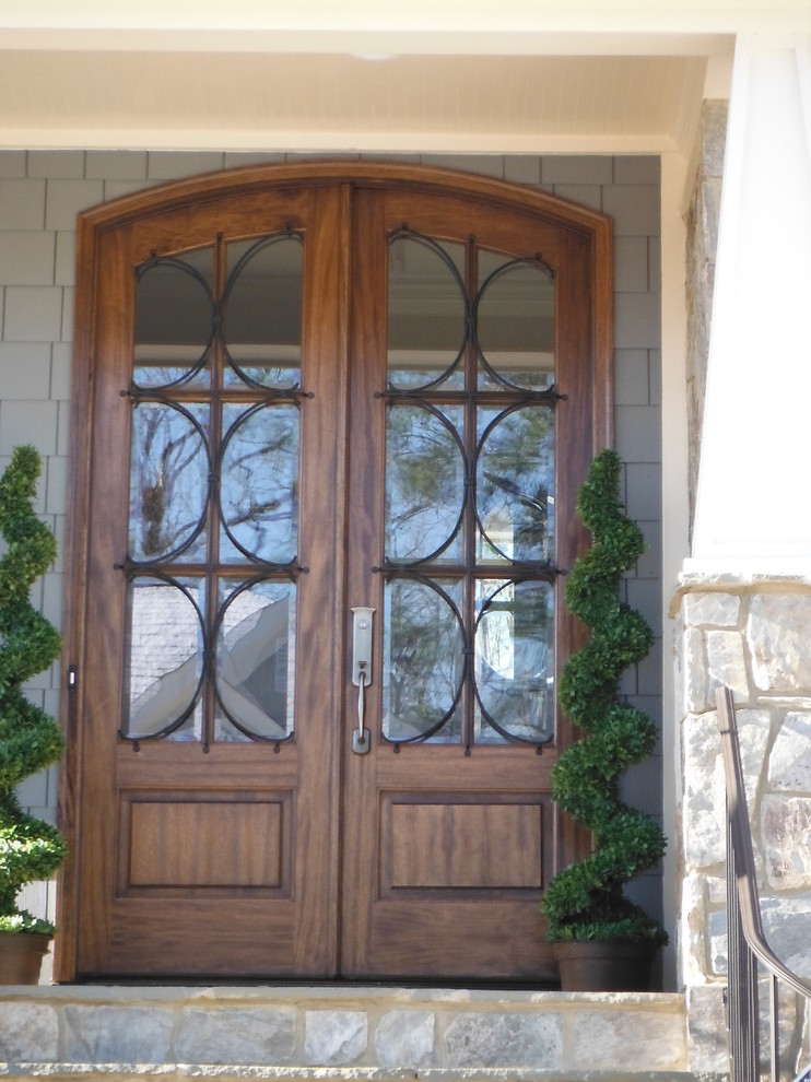 Ejemplo de entrada clásica con puerta doble y puerta de madera en tonos medios