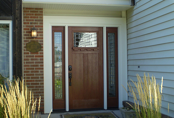 Exemple d'une porte d'entrée chic de taille moyenne avec un mur beige, sol en béton ciré, une porte simple et une porte en bois foncé.