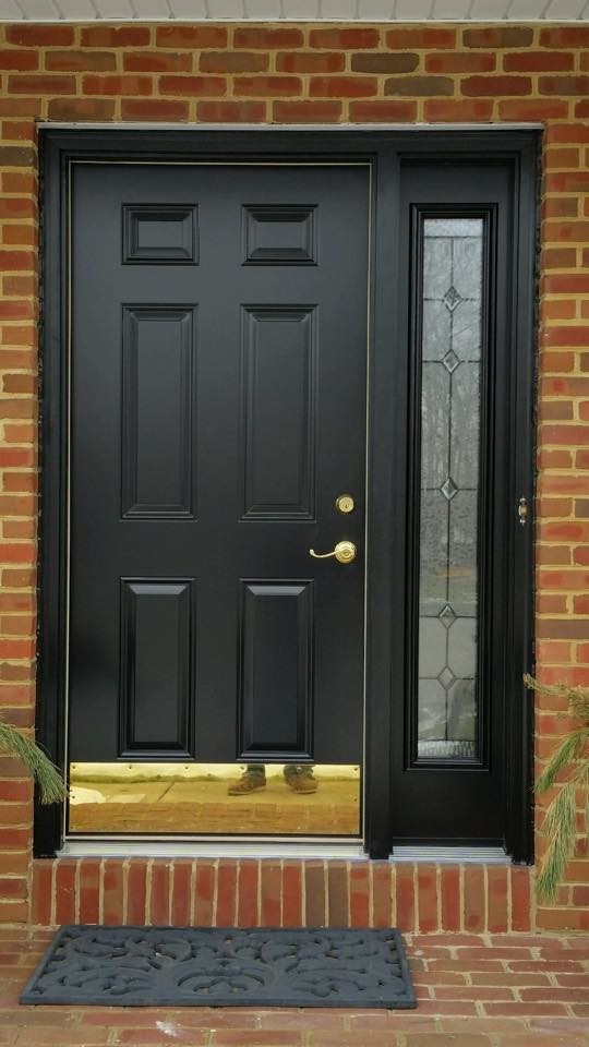 Пример оригинального дизайна: большая входная дверь с красными стенами, кирпичным полом, одностворчатой входной дверью и черной входной дверью