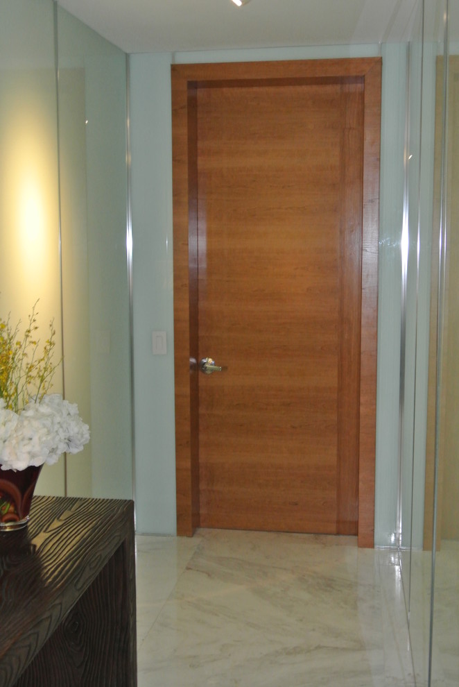 Esempio di un corridoio moderno di medie dimensioni con pareti bianche, pavimento in marmo, una porta a due ante e una porta in legno chiaro