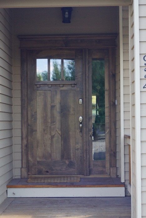 Foto de puerta principal de estilo americano de tamaño medio con puerta simple, puerta de madera oscura, paredes beige y suelo de madera clara