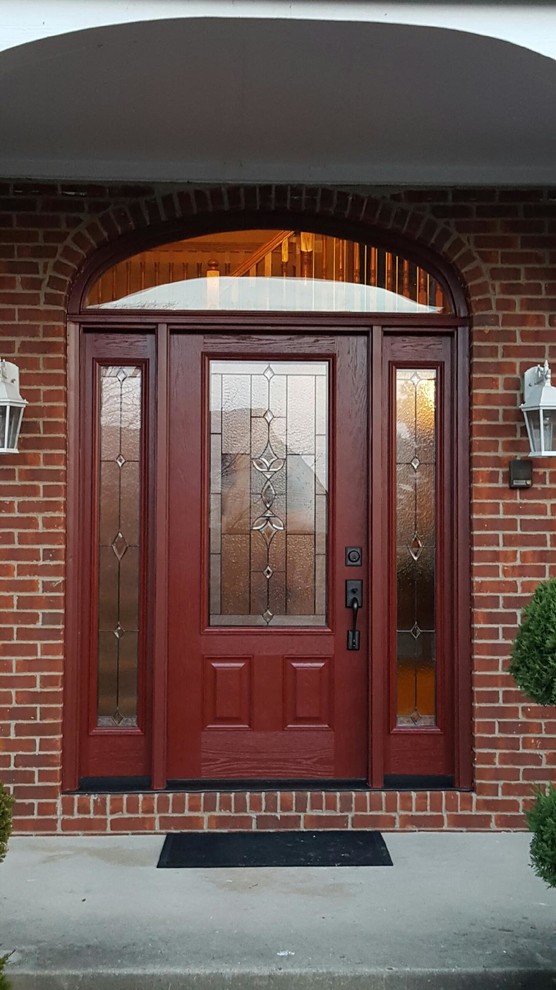 Пример оригинального дизайна: входная дверь среднего размера в стиле кантри с одностворчатой входной дверью, красной входной дверью, красными стенами и бетонным полом
