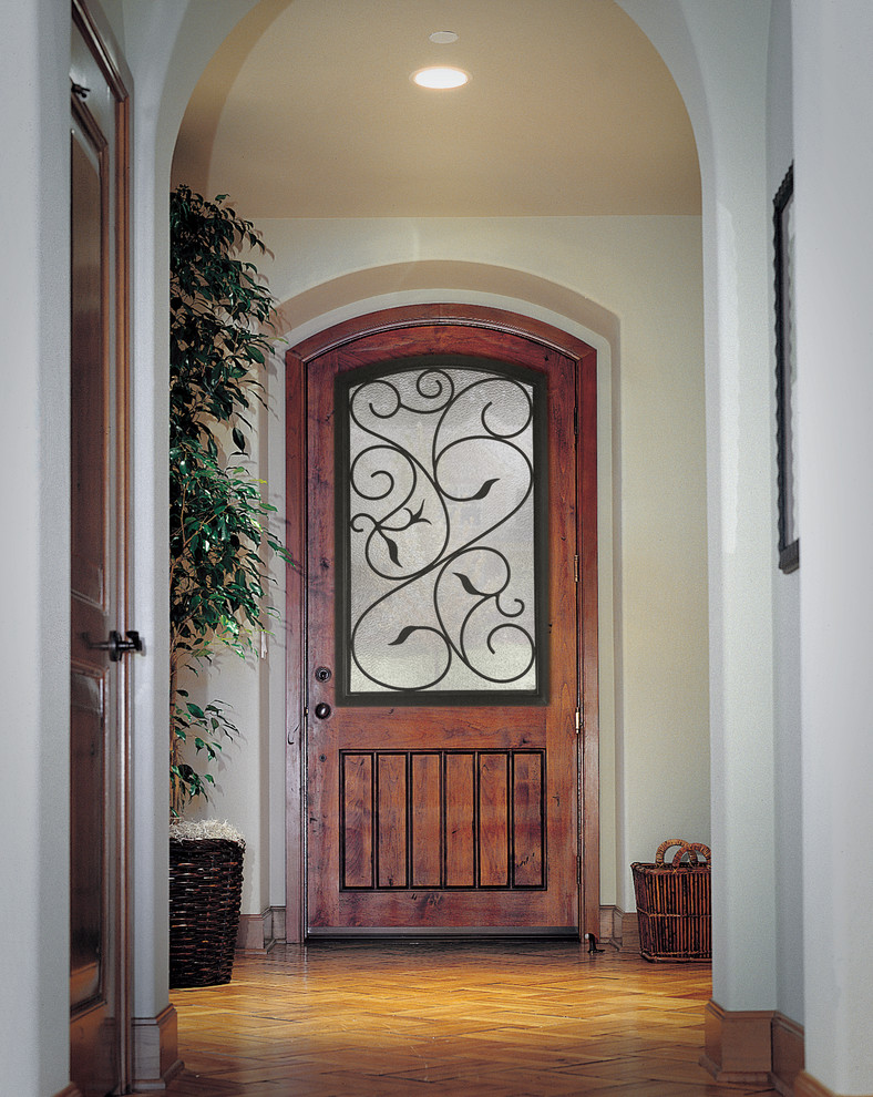 Стильный дизайн: входная дверь среднего размера в средиземноморском стиле с белыми стенами, паркетным полом среднего тона, одностворчатой входной дверью, входной дверью из дерева среднего тона и коричневым полом - последний тренд