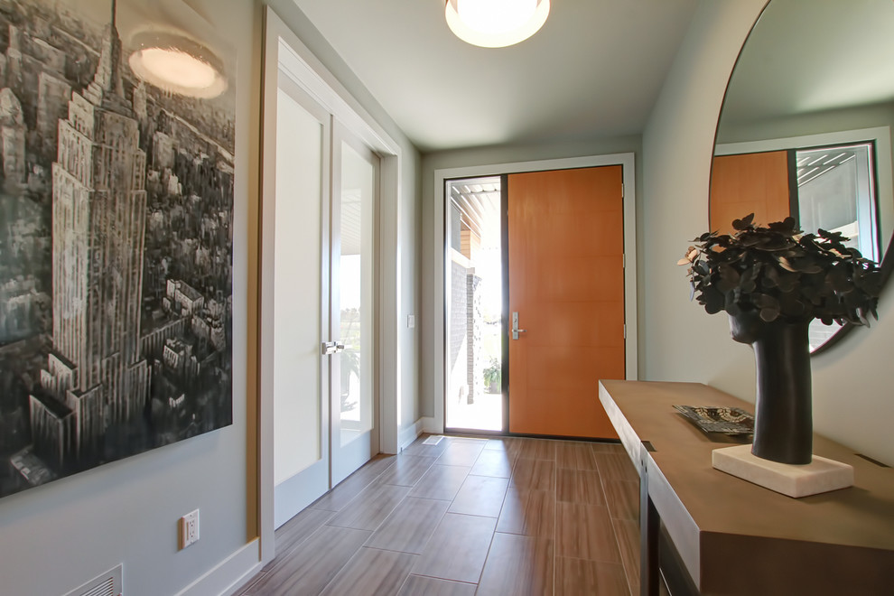 Источник вдохновения для домашнего уюта: узкая прихожая среднего размера в современном стиле с бежевыми стенами, темным паркетным полом, одностворчатой входной дверью, входной дверью из светлого дерева и коричневым полом