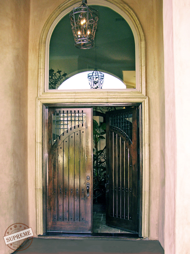 ロサンゼルスにあるお手頃価格の中くらいなコンテンポラリースタイルのおしゃれな玄関ドア (ベージュの壁、コンクリートの床、濃色木目調のドア) の写真