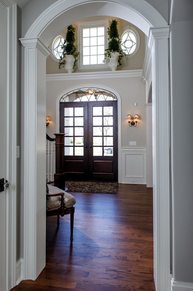 Réalisation d'une porte d'entrée tradition de taille moyenne avec une porte double et une porte en bois foncé.