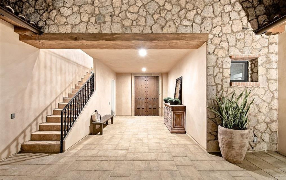 Geräumige Mediterrane Haustür mit beiger Wandfarbe, Kalkstein, Doppeltür, dunkler Holzhaustür und beigem Boden in San Diego