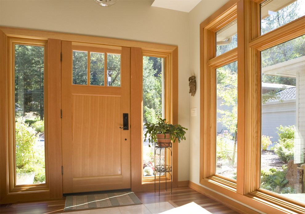 Modernes Foyer mit beiger Wandfarbe, hellem Holzboden und heller Holzhaustür in Seattle