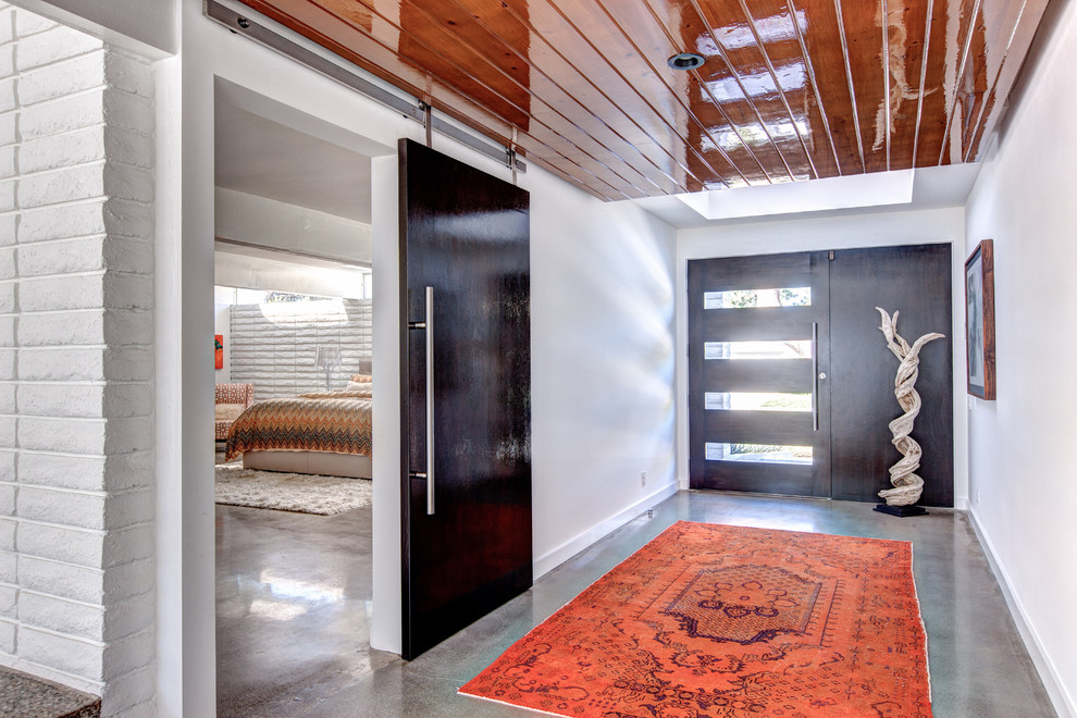 Large trendy concrete floor and gray floor entryway photo in Orange County with white walls and a glass front door