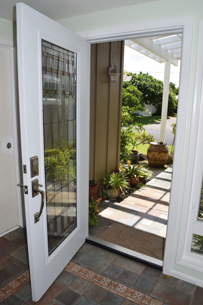 Modelo de puerta principal mediterránea de tamaño medio con paredes verdes, puerta simple, puerta blanca y suelo de baldosas de terracota