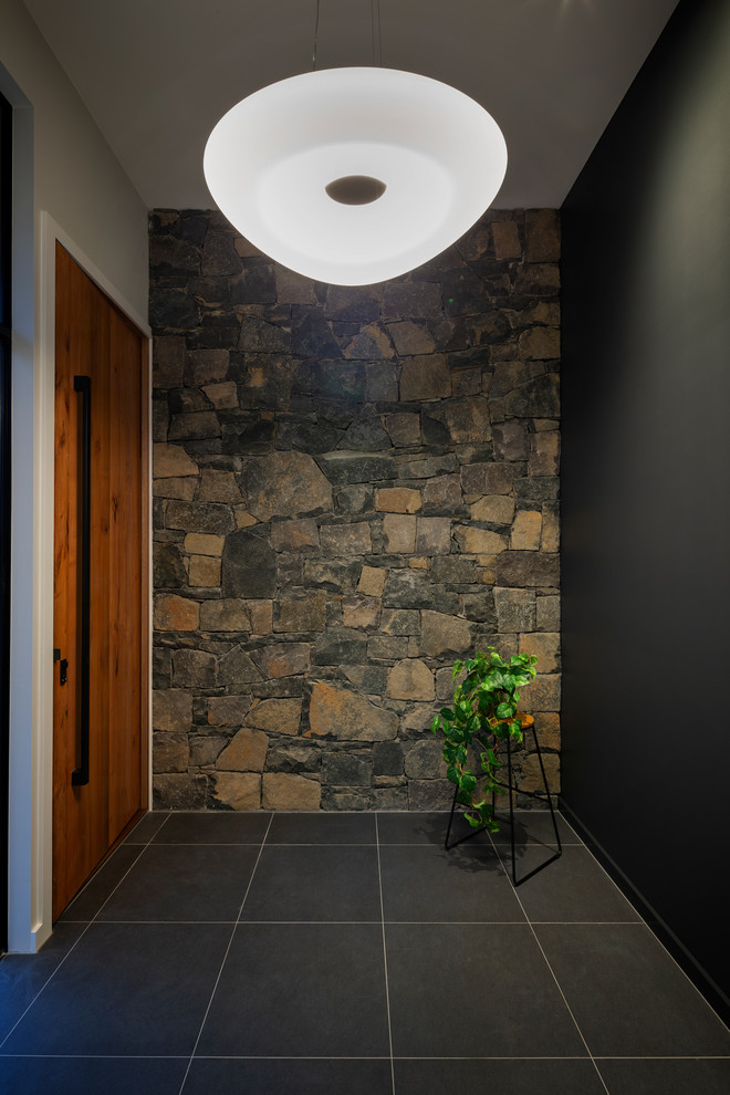 Moderne Haustür mit schwarzer Wandfarbe, Porzellan-Bodenfliesen, Drehtür, hellbrauner Holzhaustür und schwarzem Boden in Canberra - Queanbeyan