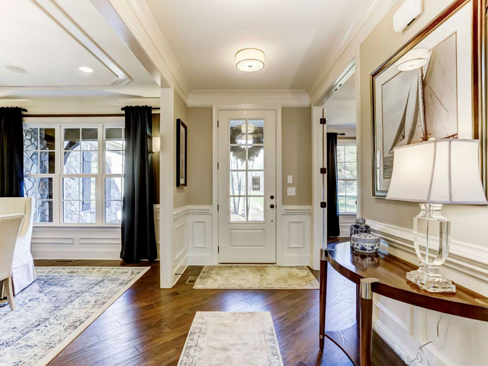 Mittelgroßes Foyer mit beiger Wandfarbe, braunem Holzboden, Einzeltür, weißer Haustür und vertäfelten Wänden in Charlotte