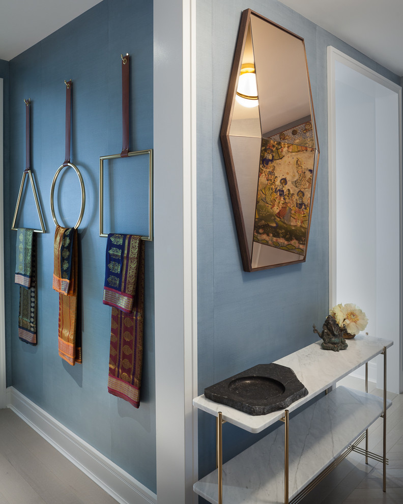 Diseño de distribuidor actual de tamaño medio con paredes azules, suelo de madera clara, puerta simple, puerta blanca y suelo beige