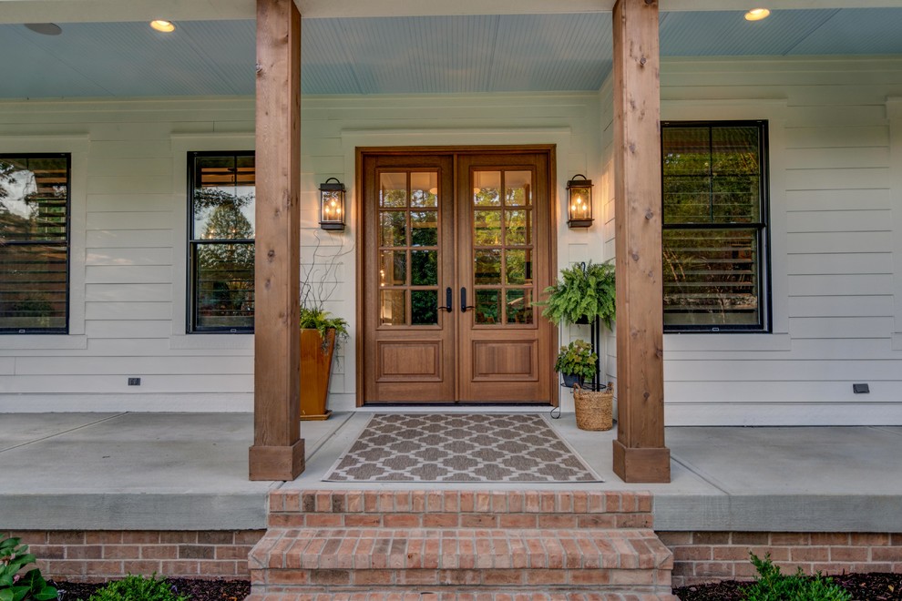 Urige Haustür mit beiger Wandfarbe, Betonboden, Doppeltür, hellbrauner Holzhaustür und grauem Boden in Indianapolis