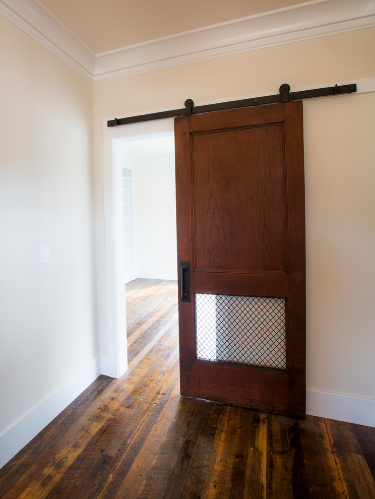 Aménagement d'un hall d'entrée craftsman de taille moyenne avec un mur beige, parquet foncé, une porte simple, une porte en bois foncé et un sol marron.
