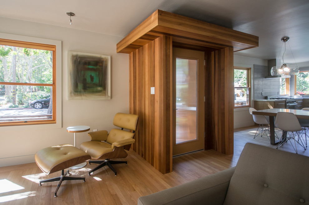 Entryway - small modern light wood floor entryway idea in Sacramento with beige walls and a brown front door