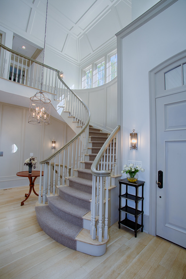 Large traditional foyer in New York with white walls, light hardwood flooring, a single front door and a grey front door.