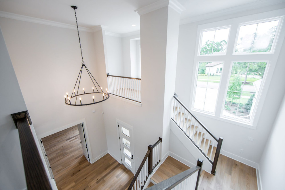 This is an example of a large classic foyer in Jacksonville with white walls, light hardwood flooring, a single front door, a white front door and brown floors.