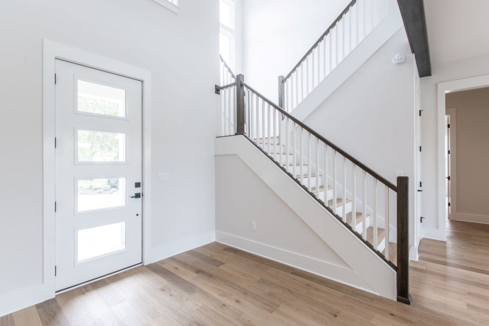Inspiration for a large transitional light wood floor and brown floor entryway remodel in Jacksonville with white walls and a white front door