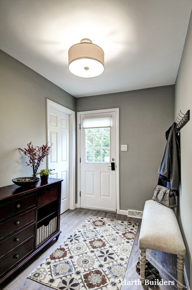 Ispirazione per un piccolo ingresso con anticamera tradizionale con pareti grigie, pavimento in laminato e una porta bianca