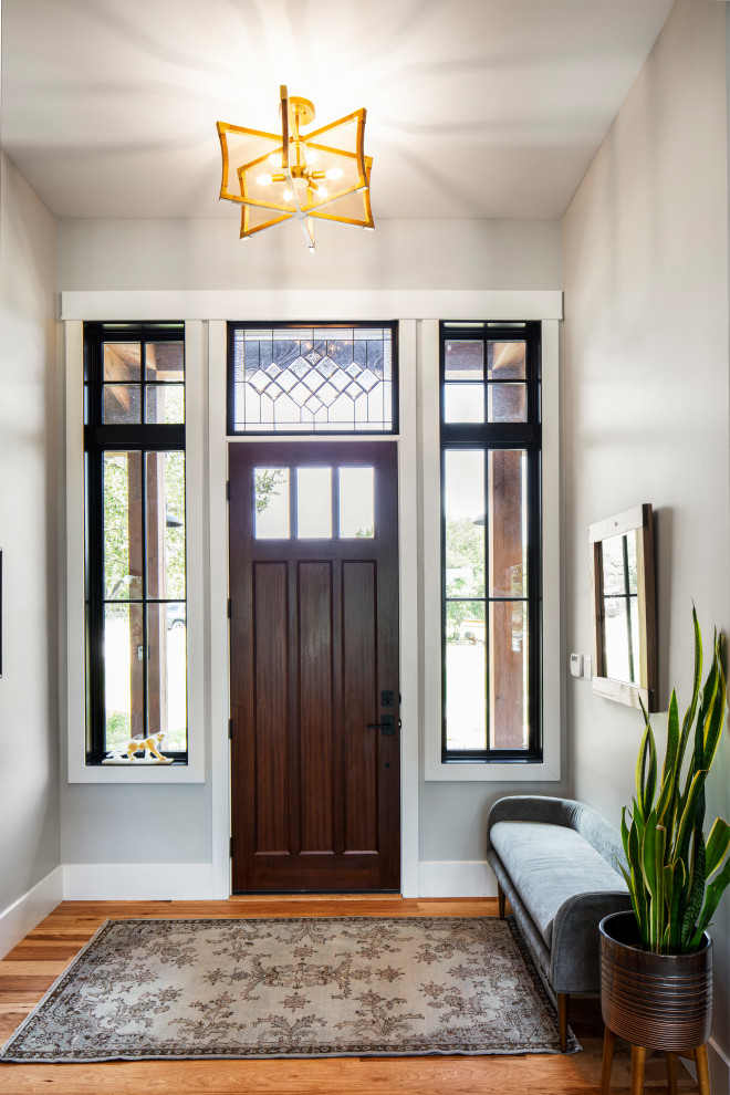 Landhaus Eingang mit grauer Wandfarbe, braunem Holzboden, Einzeltür, hellbrauner Holzhaustür und braunem Boden in Austin
