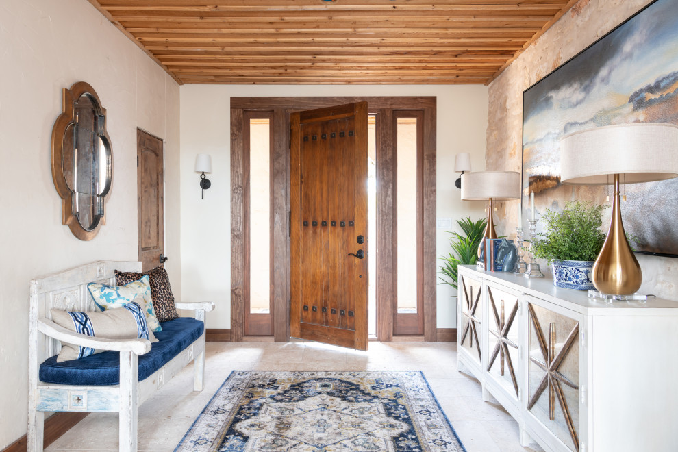 Mediterranes Foyer mit weißer Wandfarbe, Einzeltür, hellbrauner Holzhaustür, beigem Boden und Holzdecke in Austin