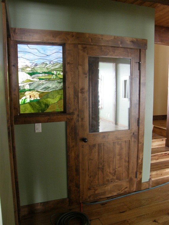 ボイシにある中くらいなラスティックスタイルのおしゃれな玄関ドア (無垢フローリング、濃色木目調のドア、緑の壁) の写真