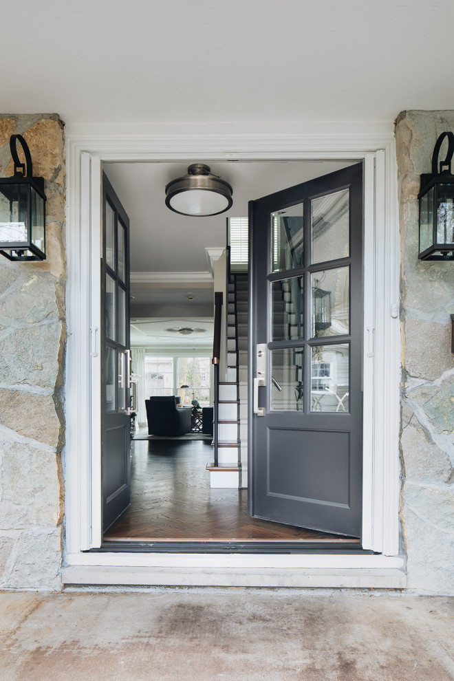 Aménagement d'une petite porte d'entrée classique avec un mur bleu, parquet foncé, une porte double, une porte marron et un sol marron.