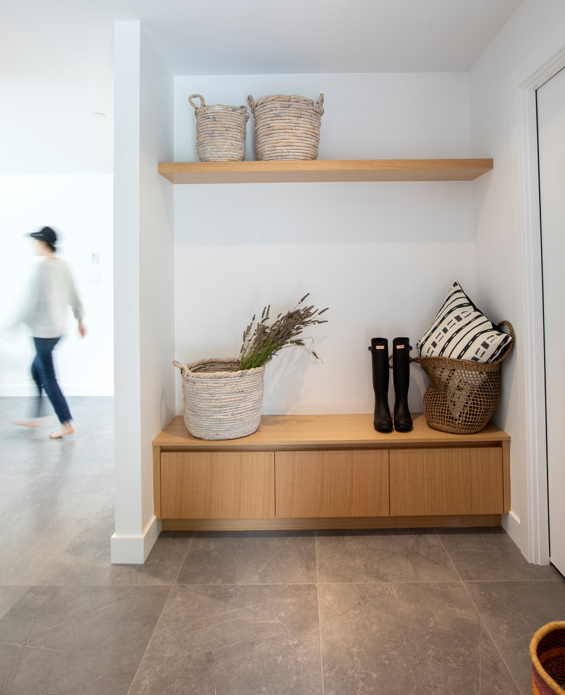 Medium sized modern boot room in Vancouver with white walls, grey floors and ceramic flooring.