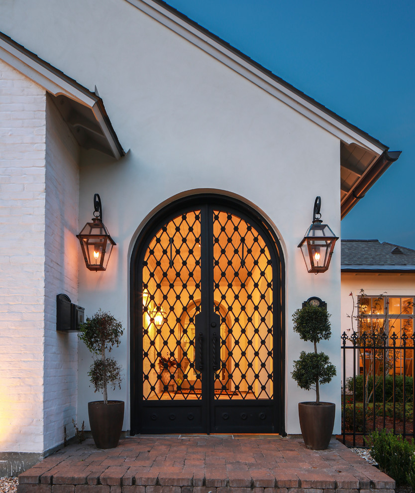 Photo of a large classic front door in New Orleans with white walls, brick flooring, a double front door and a black front door.