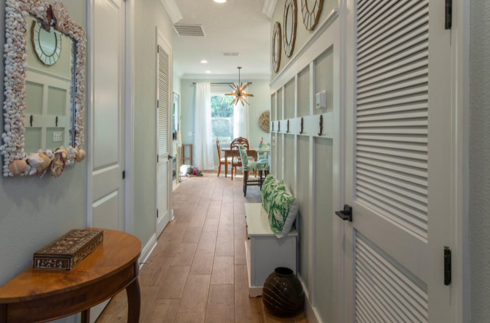 Photo of a coastal foyer in Tampa with blue walls, ceramic flooring, a single front door, a white front door and brown floors.