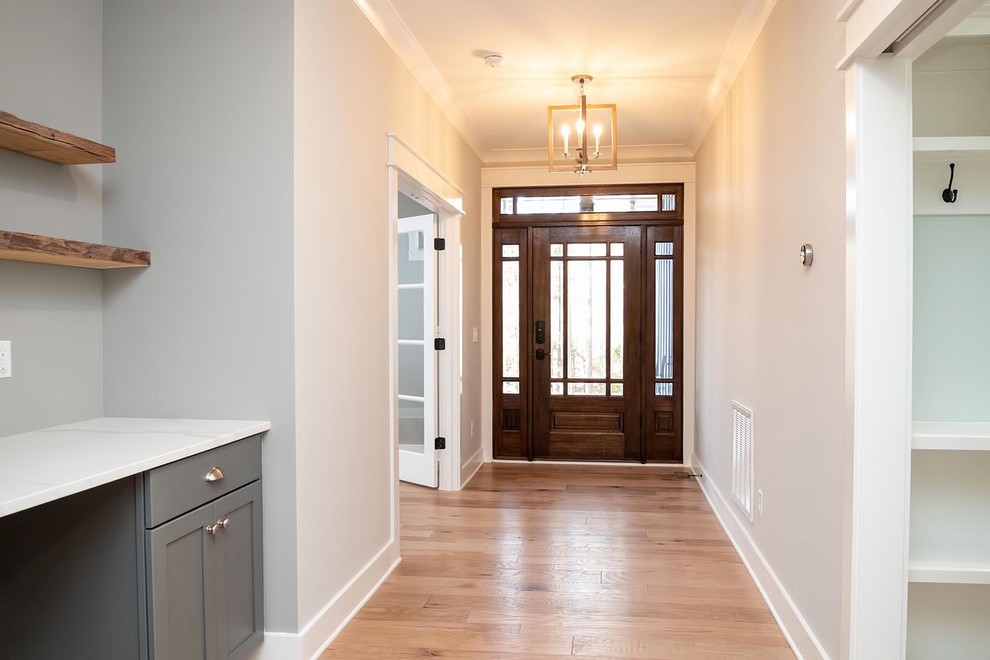 Mittelgroße Klassische Haustür mit grauer Wandfarbe, hellem Holzboden, Einzeltür, dunkler Holzhaustür und braunem Boden in Raleigh