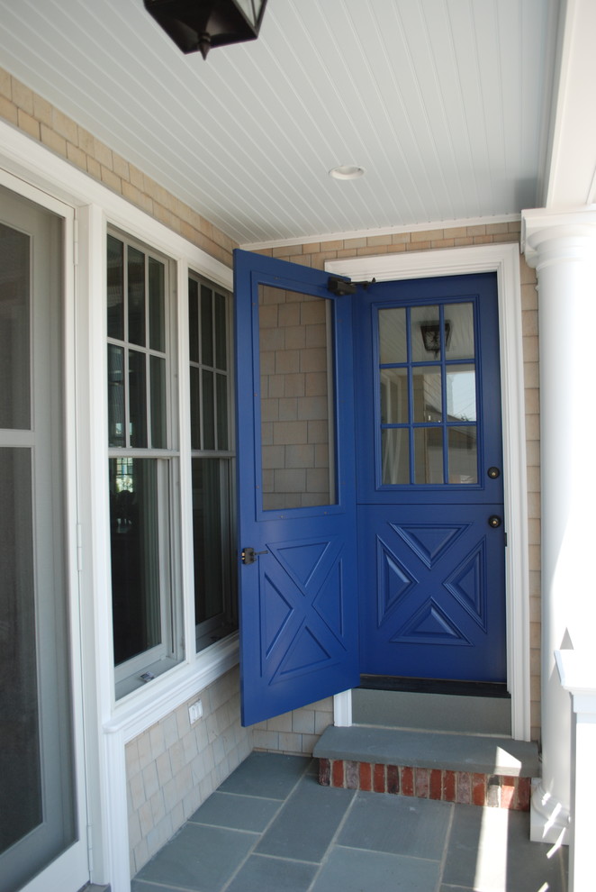 Aménagement d'une entrée campagne avec une porte hollandaise et une porte bleue.